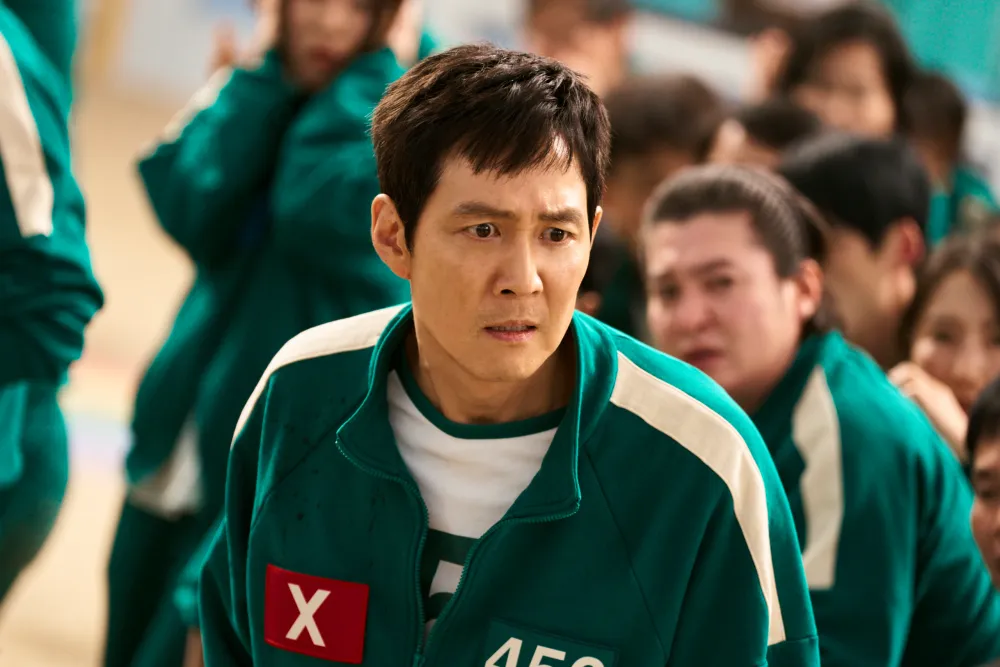 Serious-looking male participant in green tracksuit with participant number 456 badge